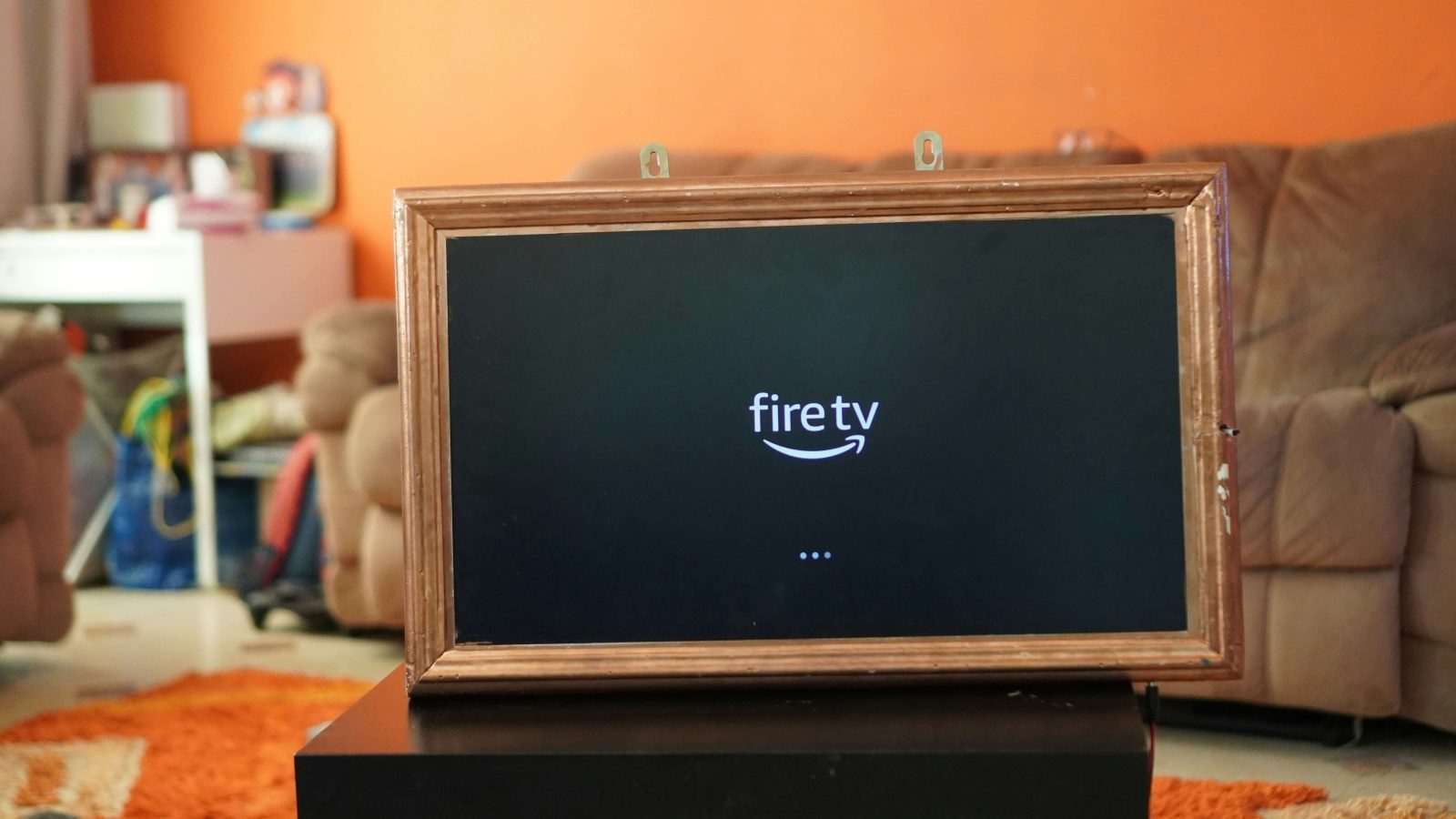 A wooden frame, showing the Fire TV logo on the screen