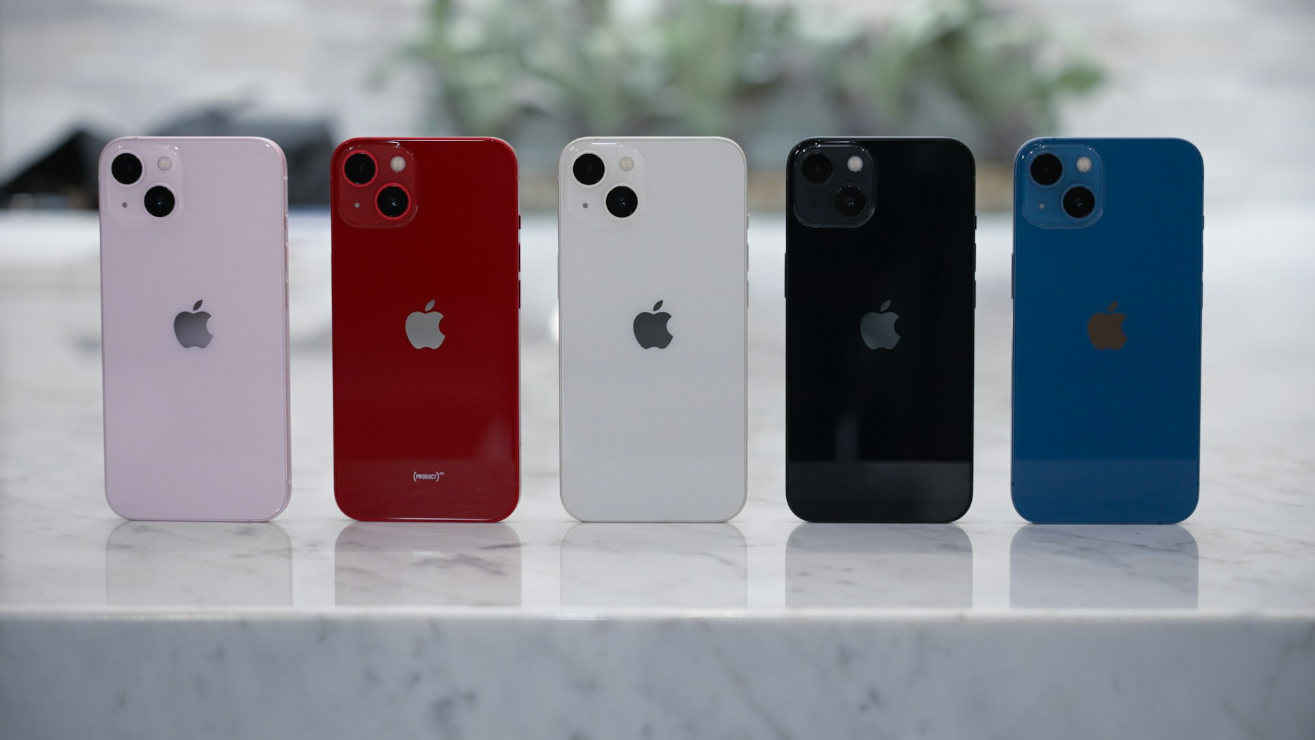 Four iPhone 13s in different colors