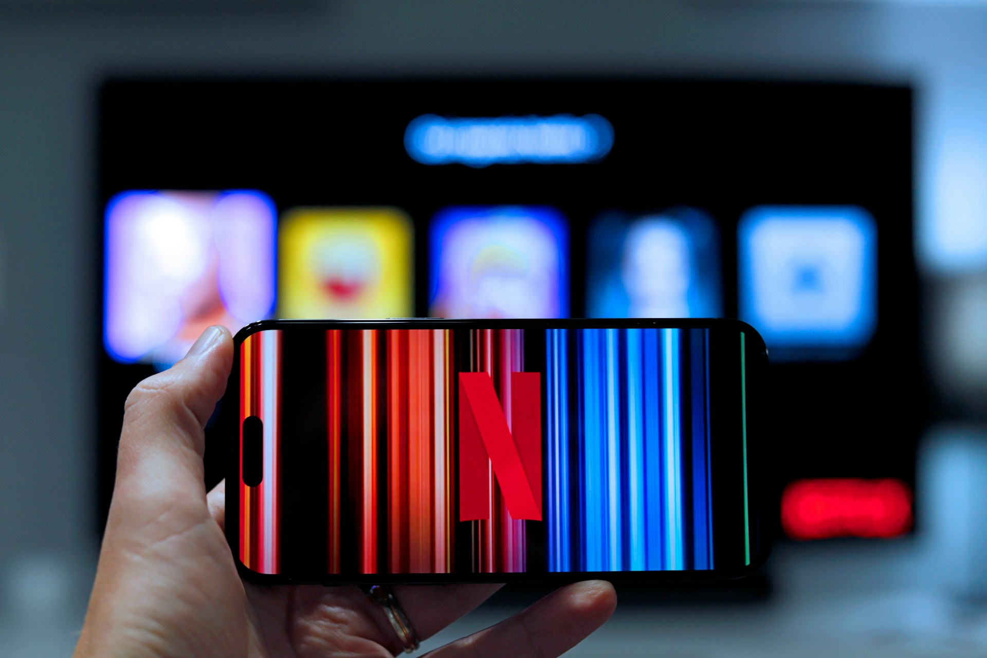 A person holding a phone with Netflix logo